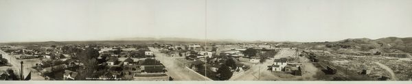 Panorama of Tombstone, Arizona, in 1909: low buildings spread across the desert below the hills.